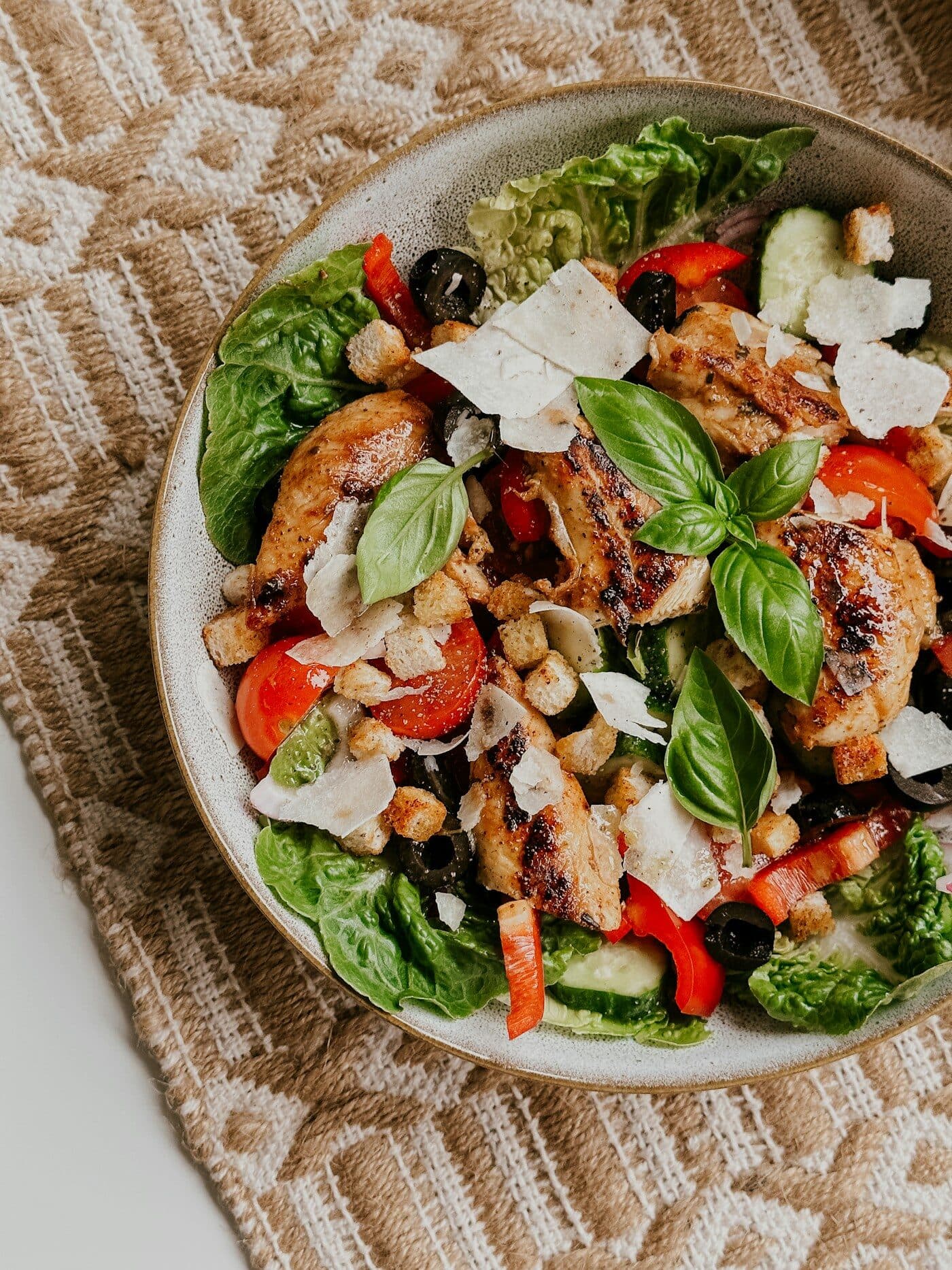 Salada colorida com frango grelhado, tomate, folhas verdes e lascas de queijo